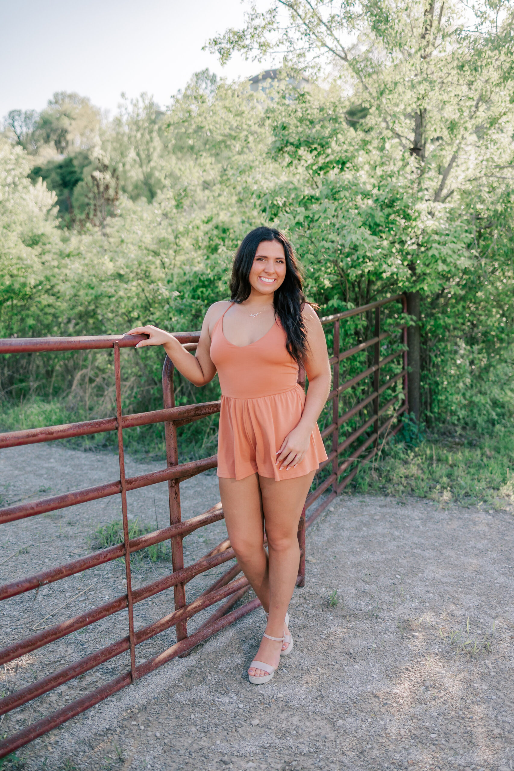 A high school senior stands against a rusted gate in a gravel path st louis tutors