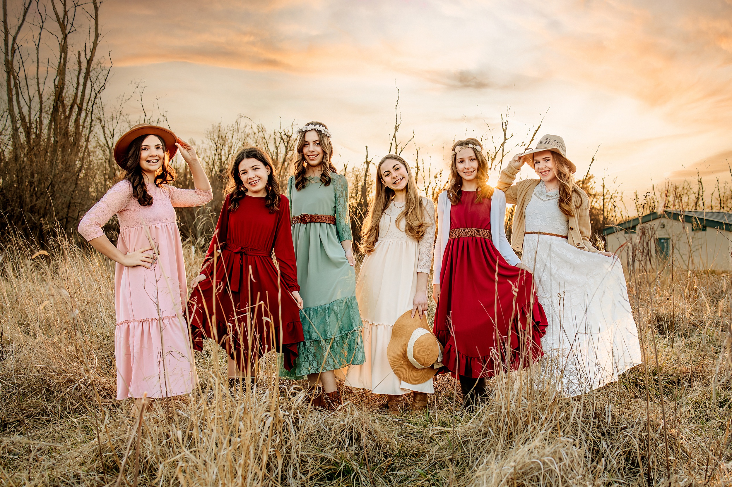 Six sisters stand in a field of tall golden grass at sunset in long dresses things to do in st louis with kids